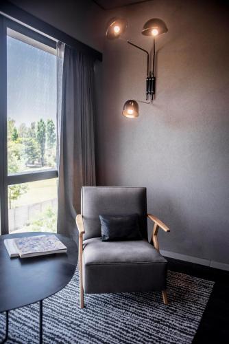 a living room with a chair and a table and a window at KOS Pilar Hotel in Pilar