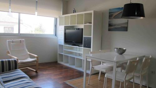 salon ze stołem i telewizorem w obiekcie Apartamento playa Isla de Arosa w mieście Isla de Arosa