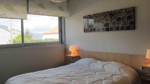 イスラ・デ・アローサにあるApartamento playa Isla de Arosaのベッドルーム1室(白いベッド1台、窓2つ付)