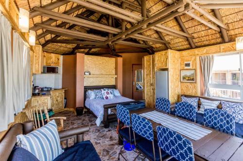 1 dormitorio con 1 cama y sillas en una habitación en Walkerview Apartments, en Gansbaai