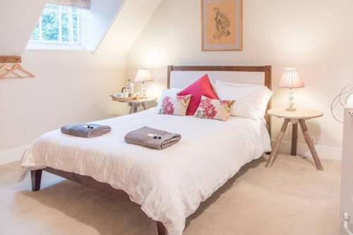 a bedroom with a large white bed with pillows at Castle Cottage Orford in Orford