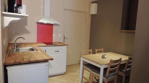 ル・ブール・ドアザンにあるappartement des Alpesのキッチン(シンク、テーブル、椅子付)