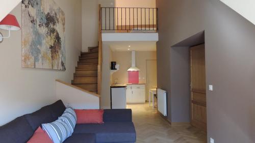 ル・ブール・ドアザンにあるappartement des Alpesのリビングルーム(青いソファ、階段付)