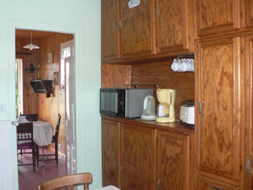 - une cuisine avec des placards en bois et un four micro-ondes dans l'établissement Clo Hujobe, à Parthenay