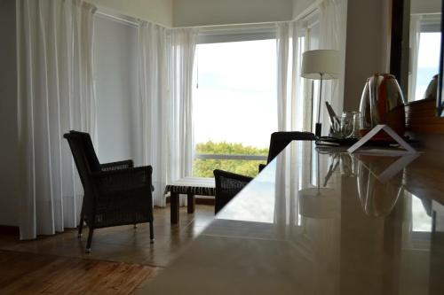a living room with a table and chairs and a window at Costanera Mar Hotel & Suites in San Clemente del Tuyú