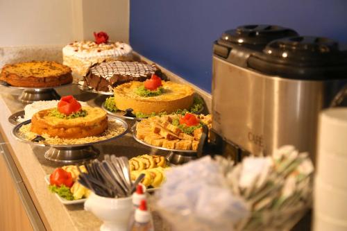 a buffet with cakes and other desserts on plates at Real Praia Hotel in Aracaju