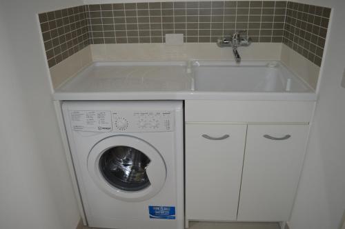 a washing machine in a kitchen with a sink at Casa Ferreri in Santa Ninfa