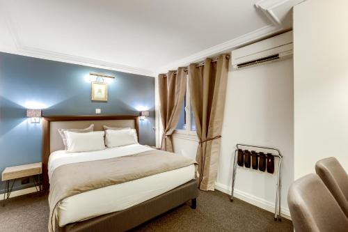 a hotel room with a bed and a chair at Hotel Opera Maintenon in Paris