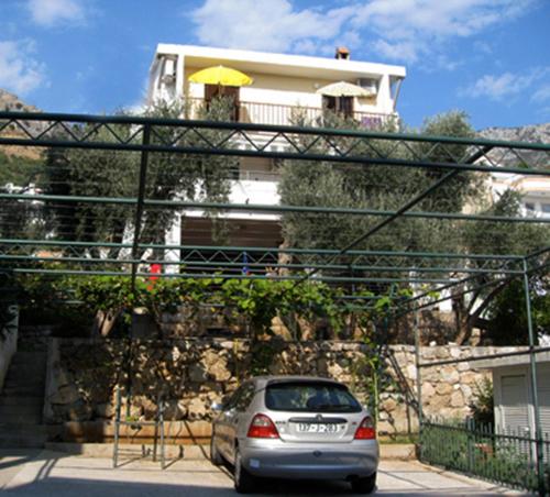 a silver car parked in front of a house at Apartments Maslina in Sveti Stefan