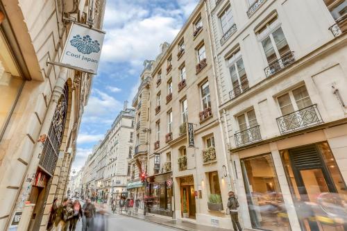a city street with buildings and people walking down the street at Hotel Opera Maintenon in Paris