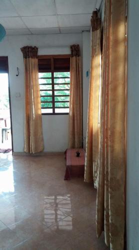 a living room with curtains and a large window at Malika Homestay in Midigama
