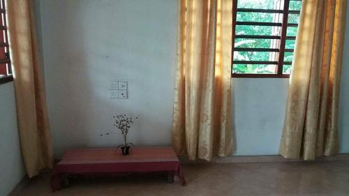 a room with a table in front of a window at Malika Homestay in Midigama