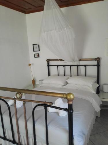a bedroom with a large bed with white sheets at Trouli House in Stalos