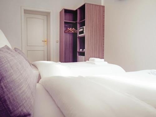 a bedroom with a bed and a dresser at dingdong bonn - city apartments in Bonn