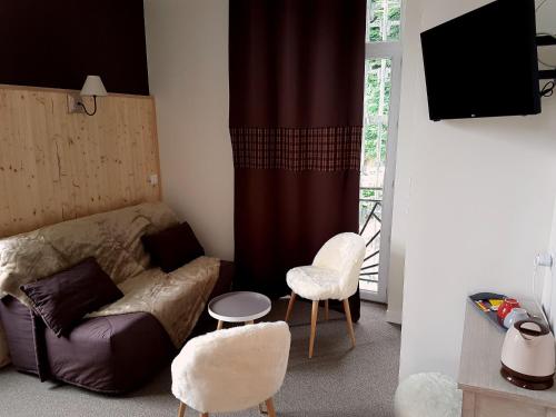 - un salon avec un canapé et deux chaises dans l'établissement Le Pavillon, à La Bourboule