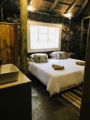 a bedroom with a bed and a sink and a window at Sasa Safari Camp & Tours in Outjo