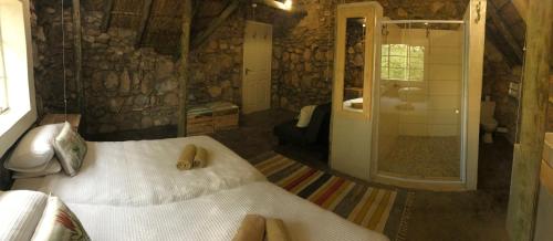 a bedroom with a bed and a bathroom with a shower at Sasa Safari Camp & Tours in Outjo