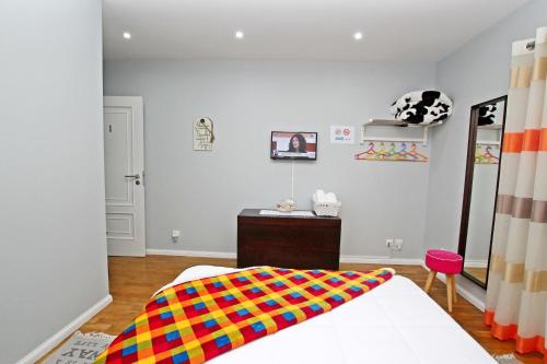 
a bedroom with a bed and a dresser at Guest House Pereira in Vila Praia de Âncora
