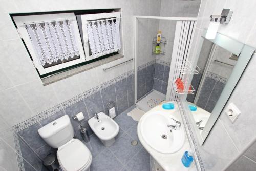 a small bathroom with a toilet and a sink at Guest House Pereira in Vila Praia de Âncora