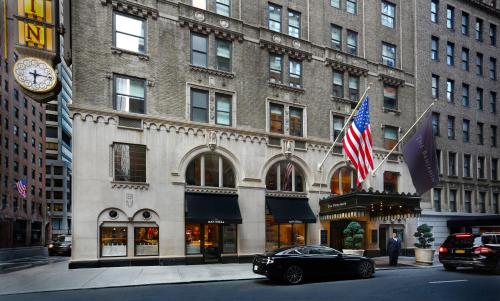 a car parked in front of a building with an american flag at The Benjamin Royal Sonesta New York in New York