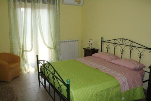 ein Schlafzimmer mit einem Bett mit einer grünen Decke und einem Fenster in der Unterkunft B&B Grande Salento in San Marzano di San Giuseppe
