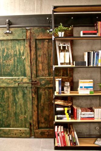 a book shelf next to a wooden door with books at Pove 2.4 Hotel in Pove del Grappa