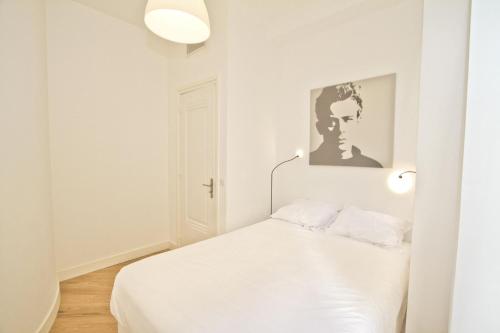 - une chambre blanche avec un lit et deux lumières dans l'établissement PROMENADE HOLIDAY - SOLEMAR PROMENADE, à Nice