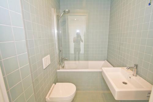 une personne prenant une photo d'une salle de bains avec toilettes et lavabo dans l'établissement PROMENADE HOLIDAY - SOLEMAR PROMENADE, à Nice