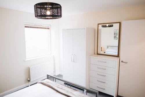 a bedroom with a bed and a mirror at Comfortable Belfast city centre apartment in Belfast