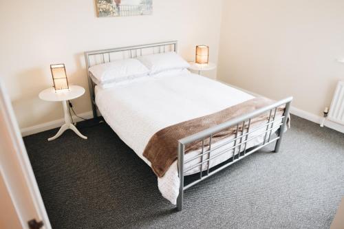 a bedroom with a bed and two lamps on two tables at Comfortable Belfast city centre apartment in Belfast