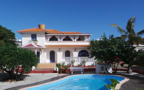 uma casa com uma piscina em frente em Shanti Villa em Flic-en-Flac