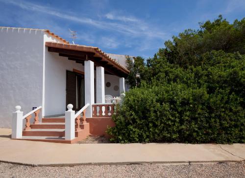 a small white house with a porch and stairs at Viviendas Los Olivos - Formentera Break in Playa Migjorn