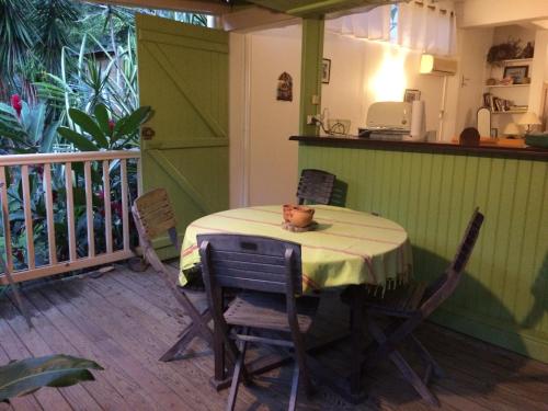 a table and chairs in a room with a balcony at Villa et Gites Le Safran - Le Triskell in Deshaies