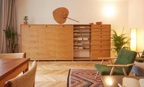 ein Wohnzimmer mit einem Holzschrank und Stühlen in der Unterkunft Warsaw Concierge Saska Studio in Warschau