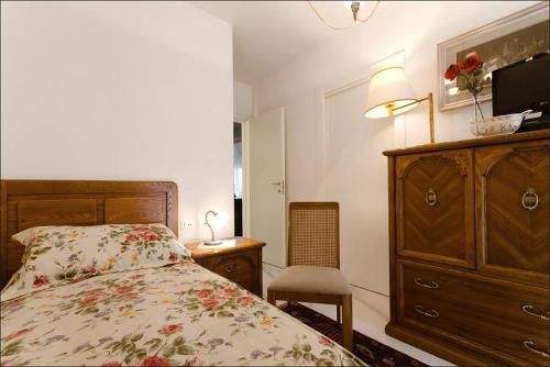 a bedroom with a bed and a dresser with a television at Bed and Breakfast Grace in LʼAquila