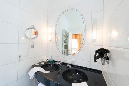 a bathroom with a sink and a mirror at Hotel Alte Post in Wangen im Allgäu