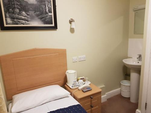 a small bathroom with a bed and a sink at Central Hotel in London