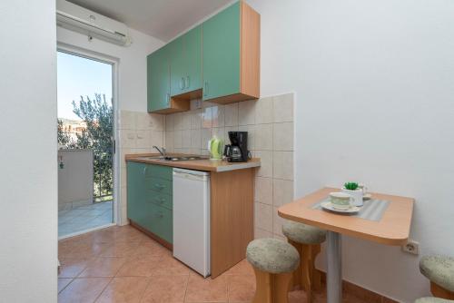 Gustirna的住宿－Apartments Ivana-Gustirna，厨房配有绿色橱柜和小桌子
