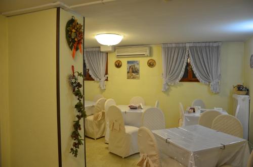 a dining room with a table and white chairs at Hotel Arcella in Padova