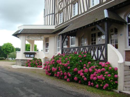 a building with pink flowers in front of a building at Hostellerie Saint Pierre in Saint-Pierre-du-Vauvray