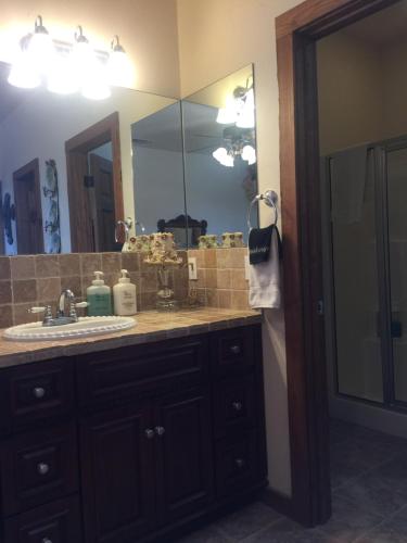 a bathroom with a sink and a large mirror at Glory Hills Ranch in Pipe Creek