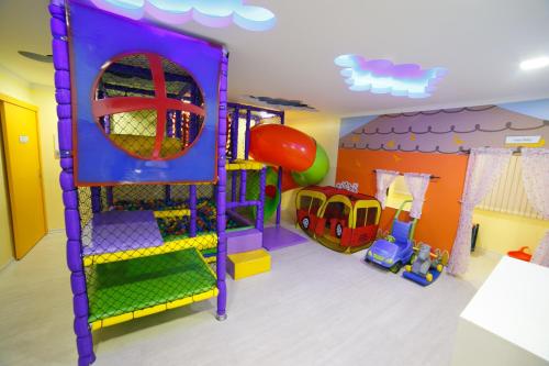 a play room with a slide and a playground at Herval Park Hotel in Ponta Porã