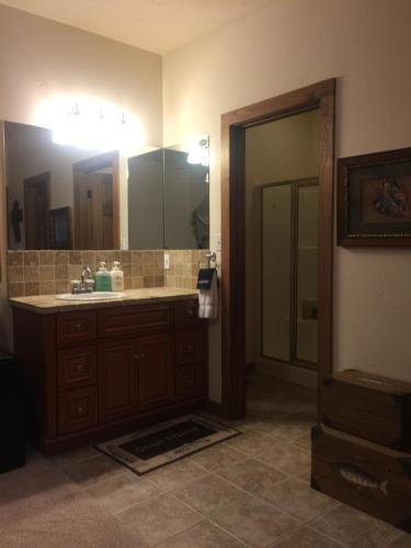 a bathroom with a sink and a large mirror at Glory Hills Ranch in Pipe Creek