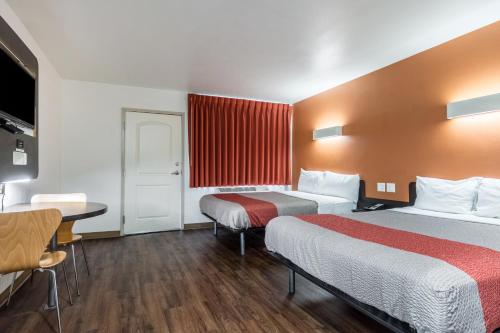 a hotel room with two beds and a table at Pacific Inn in Oceanside