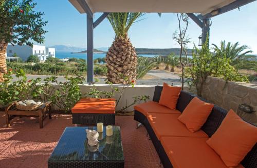 patio con divano arancione e tavolo in vetro di Maistrali Apartments a Diakofti