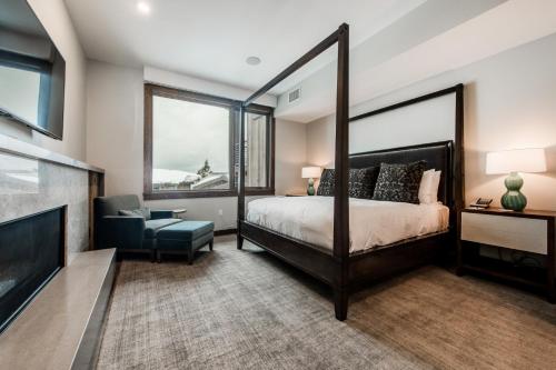 a bedroom with a large bed and a chair at Stein Eriksen Residences in Park City