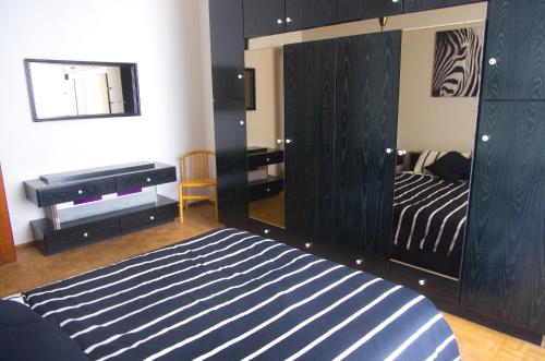 博爾迪蓋拉的住宿－Appartamento Corso Italia "Natura"，一间卧室配有一张带镜子和钢琴的床