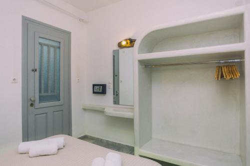 baño con cama, espejo y puerta en Astra Apartments en Agios Prokopios