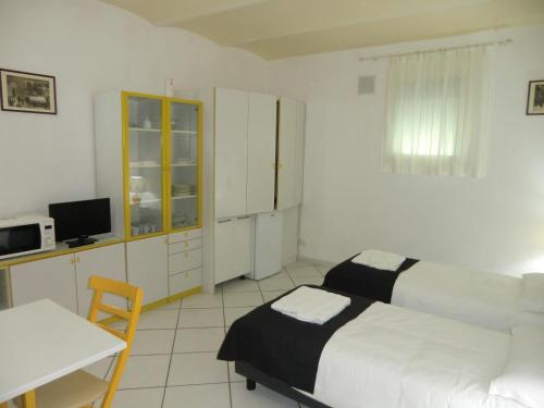 a bedroom with two beds and a table and a desk at VILLA ALMA 2 in Bologna