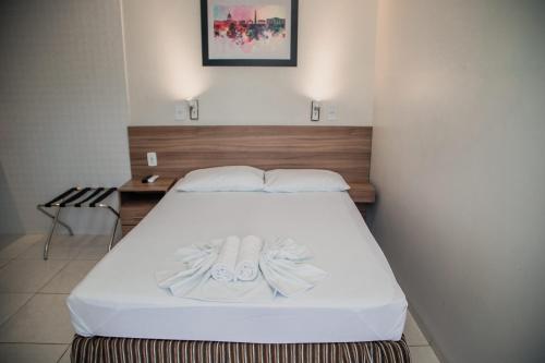 uma cama com duas toalhas num quarto em Hotel Astoria em Palmas